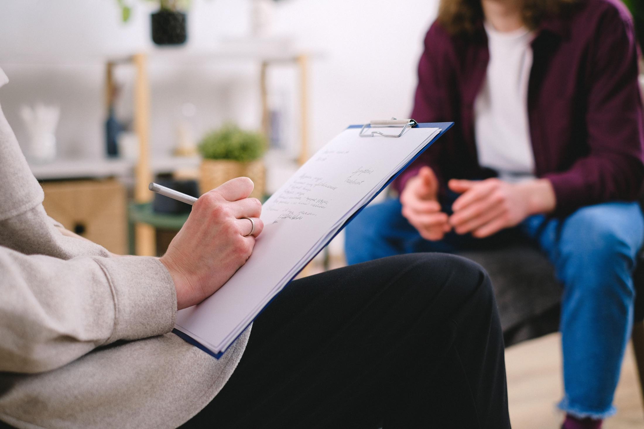 Clinician taking notes during a client assessment