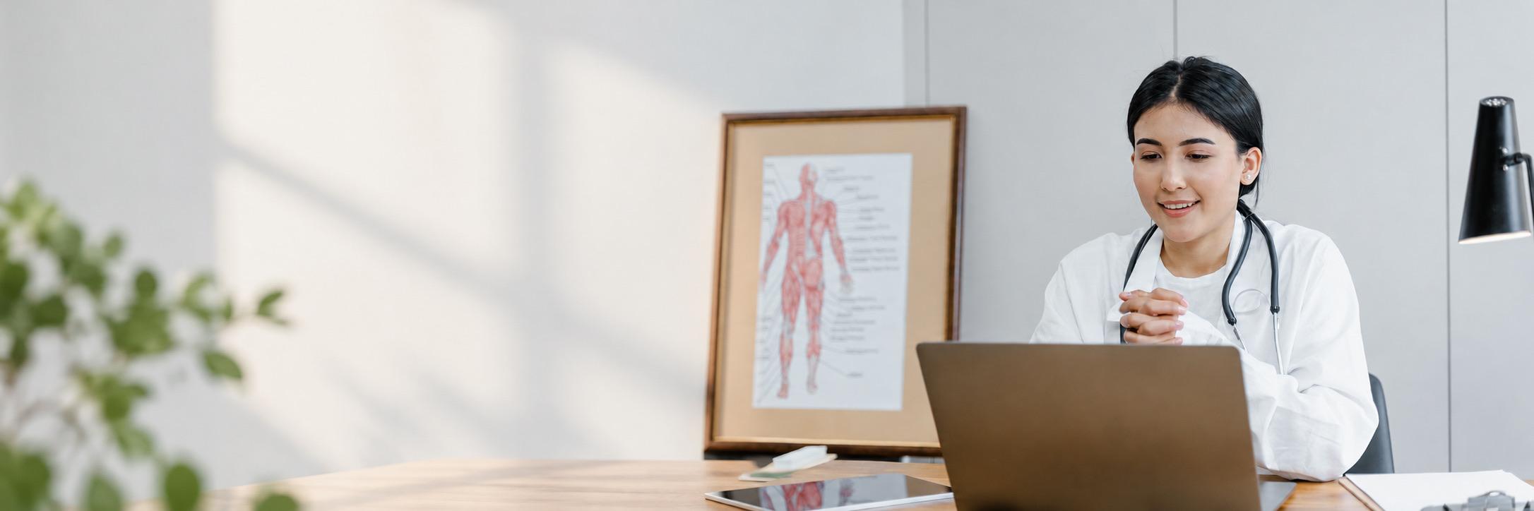 Physician reviewing a client file on a laptop
